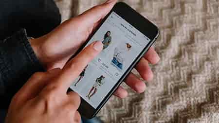 finger selecting products on fashion ecommerce website on mobile